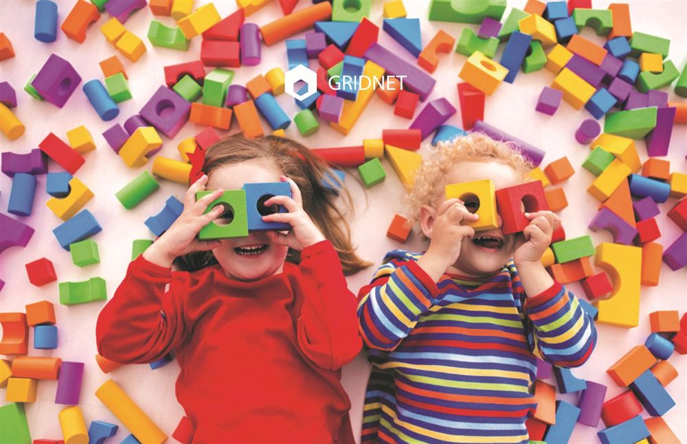 Two small children playing with colourful foam blocks