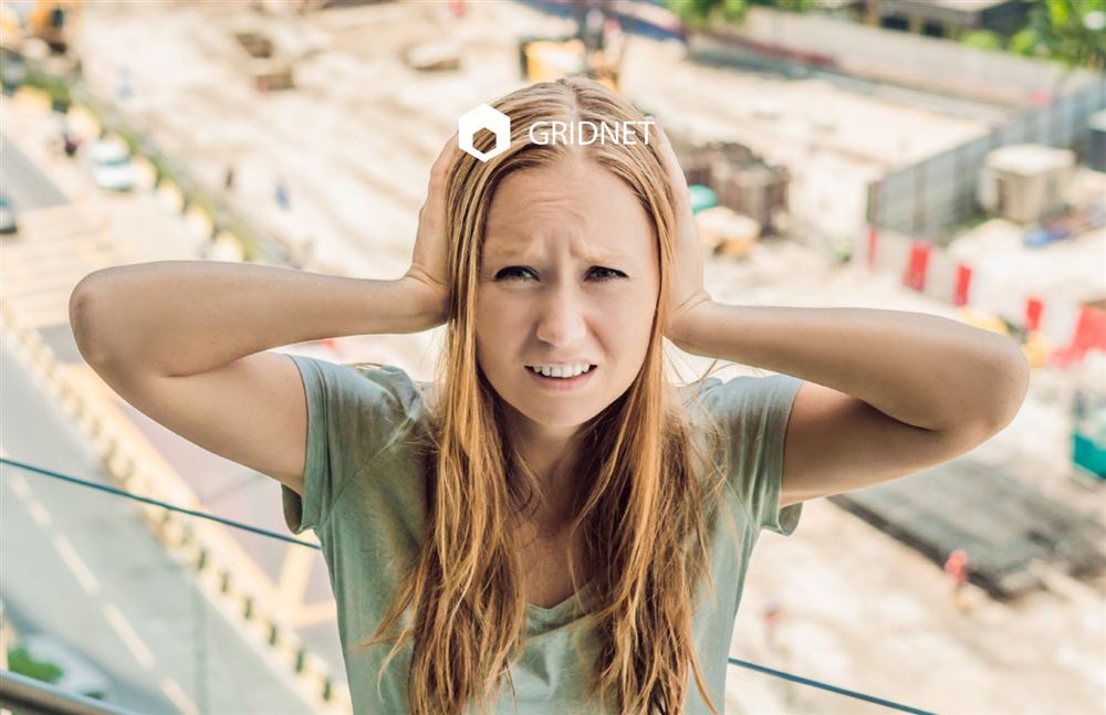 Woman covering her ears near a construction site