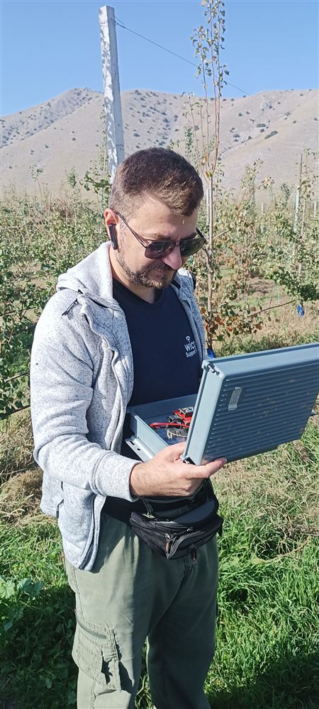 Technician recording a station location on a laptop in the field